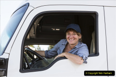 Caucasian woman truck driver in the cab of her commercial truck at a truck stop