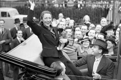 Aviator Amy Johnson waving to the crowd as she drove away from Croydon airport after her tumultous welcome after returning from the Cape, on May 15, 1936. (AP Photo)